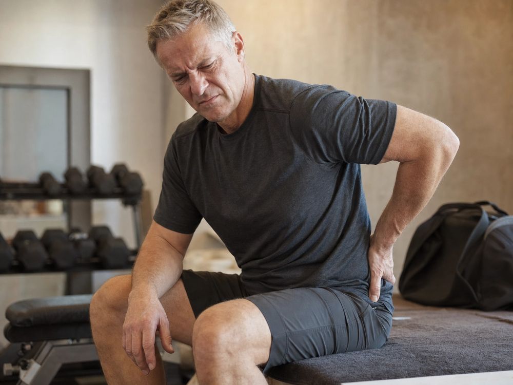 A man sitting on the gym floor between sets, recovery taking longer than it used to